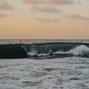 Captivating sunset over Sayulita Beach, Mexico with crashing waves and colorful sky.